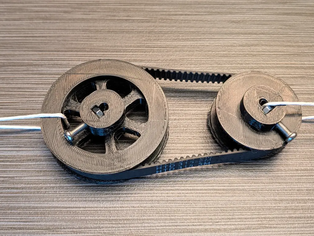 The printed HTD 3M drive from above: the six-spoke 60-tooth pulley and the 40-tooth pulley, each with a D-flat bore and one M4 set screw